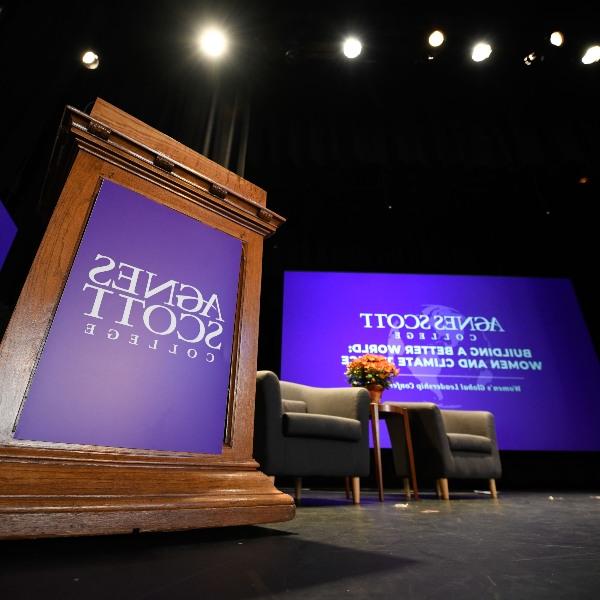 A podium with a purple Agnes Scott College banner sits on a stage